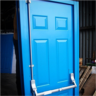 A blue steel security fire exit door with exidor crash bar propped up by a human inside a factory